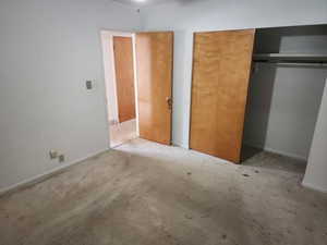 Unfurnished bedroom with a closet and baseboards