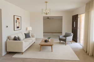 Carpeted living room featuring a chandelier and ceiling fan