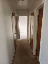 Hall featuring carpet floors and a textured ceiling