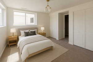 Bedroom featuring two closets and light colored carpet