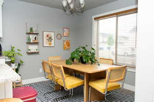 Dining area with baseboards and a chandelier