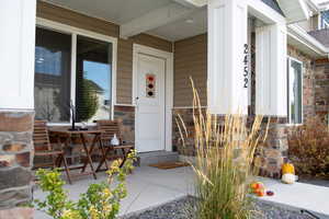 Property entrance featuring stone siding and covered porch