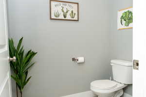 Half bath with toilet and baseboards