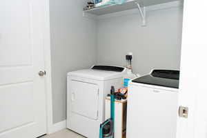 Washroom with washer and clothes dryer and baseboards