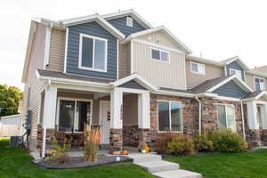 Craftsman inspired home featuring a front yard, covered porch, and stone siding
