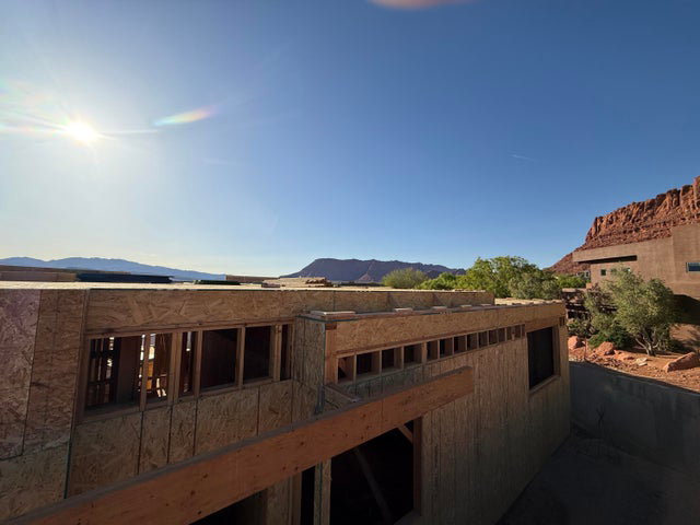 View of property exterior with a mountain view and a balcony