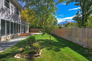 Fenced backyard featuring a sunroom and a mountain view