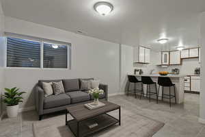 Living area with light tile patterned flooring and baseboards