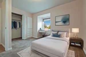 Carpeted bedroom featuring a closet and baseboards