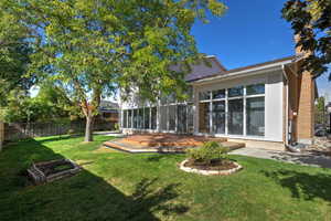 View of yard featuring a sunroom and a deck