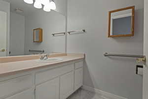Bathroom with vanity and light marble finish floors