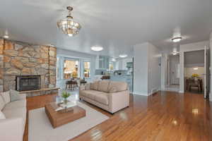Living area with hardwood / wood-style flooring and a stone fireplace