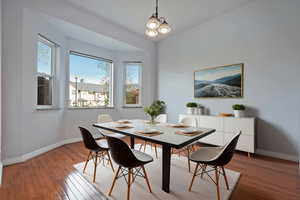 Dining room featuring hardwood / wood-style floors, healthy amount of natural light, and a chandelier