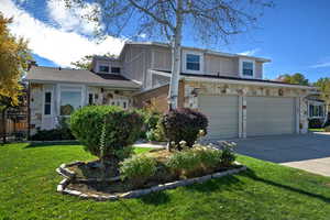 Traditional-style home featuring stone siding, concrete driveway, and an attached garage
