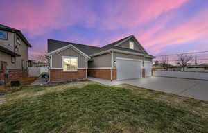 Single story home with brick siding, board and batten siding, concrete driveway, and an attached garage