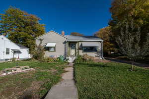 Bungalow with a front lawn and a chimney
