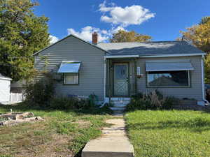 Bungalow with a front yard, a chimney, and roof with shingles