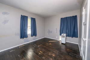 Spare room with dark wood finished floors and baseboards