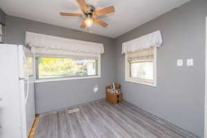 Spare room with light wood-style floors and a ceiling fan