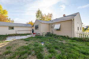 Back of property with a patio area, a chimney, and a shingled roof