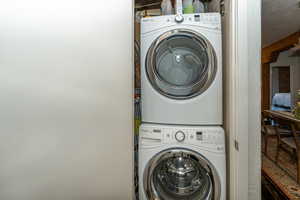 Washroom closet featuring stacked washer and dryer