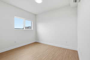 Bed room with light wood-style flooring and baseboards