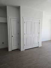 Pantry and mechanicalroom featuring dark wood-type flooring, a textured ceiling, and a closet