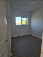 Bed room 1 featuring baseboards and dark wood-style flooring
