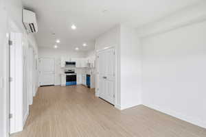Hallway featuring  light wood-style flooring, stainless steel electric range, and dishwasher