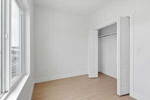 Bedroom with light wood-style floors and a closet