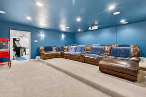 Carpeted home theater room featuring a textured ceiling and recessed lighting