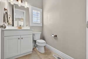 Half (guest) bathroom with vanity and light tile patterned floors
