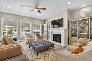 Living area featuring healthy amount of natural light, a glass covered fireplace, recessed lighting, and ceiling fan