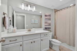 Full bathroom featuring vanity, light tile patterned floors, and shower / tub combo with curtain