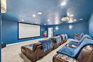 Home theater featuring carpet, a textured ceiling, and recessed lighting