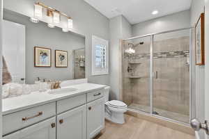 Full bathroom to second bedroom on main foor, featuring vanity and a stall shower