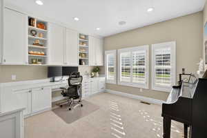 Office with built in study area, light carpet, and recessed lighting