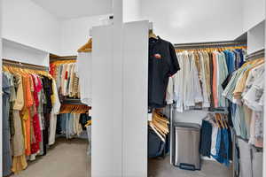Walk in closet featuring light colored carpet