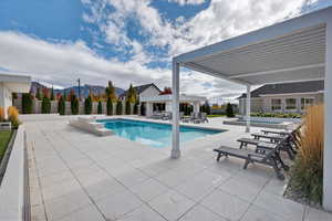 View of swimming pool featuring a patio area, a mountain view, a pergola, and a fenced backyard