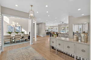 Living area with recessed lighting, light wood finished floors, and a chandelier