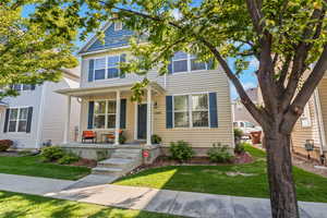 View of front of house with covered porch and a front yard