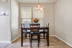 Dining room with baseboards and a chandelier
