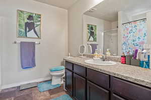Bathroom featuring a shower stall, vanity, and a textured ceiling
