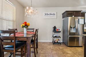 Dining space with light tile patterned flooring and a chandelier