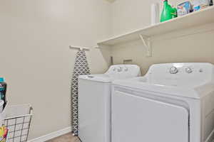 Laundry room featuring separate washer and dryer and light tile patterned flooring