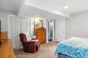 Bedroom with light carpet, a closet, and recessed lighting