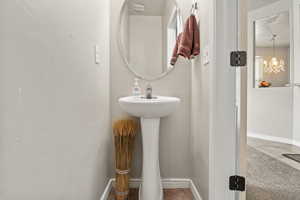 Bathroom with baseboards and a chandelier