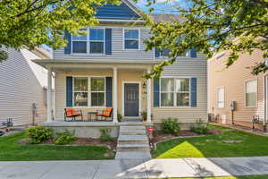 View of front of property with covered porch and a front yard