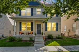 View of front facade with covered porch and a front yard