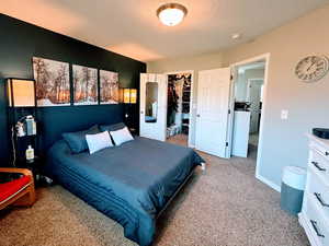 Primary bedroom featuring walk in closet and painted accent wall.